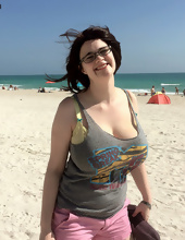 Big-tittied girl takes pictures on the beach and in the cafe