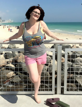 Big-tittied girl takes pictures on the beach and in the cafe