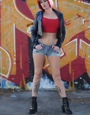 Total bimbo of a MILF toching her tits next to the wall