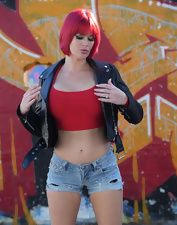Total bimbo of a MILF toching her tits next to the wall